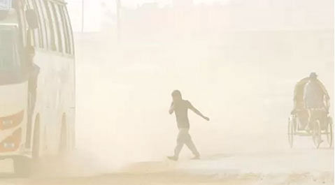 A man crosses a road covered in dust. Prothom Alo File Photo.