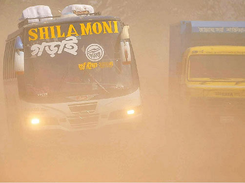 A bus runs with its headlights on amid the dust along Dhaka-Khulna Highway recently. Photo: Ehsan-Ud-Daula