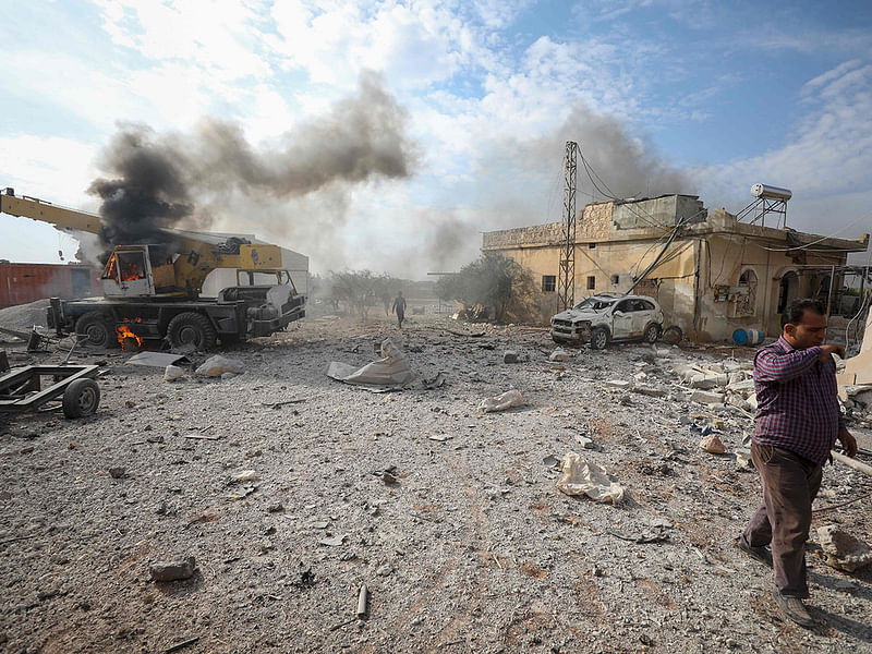 People gather amidst the rubble of buildings following an air-strike in the town of Maaret al-Naasan in the rebel-held Idlib province countryside on 24 November. Photo: AFP