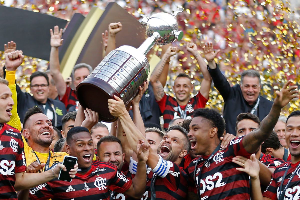 Players of Brazil`s Flamengo celebrate on the podium with the trophy after winning the Copa Libertadores final football match by defeating Argentina`s River Plate, at the Monumental stadium in Lima, on 23 November 2019. Photo: AFP