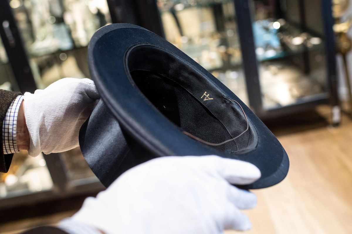 This file photo taken on 20 November shows a man holding a top hat with the initials `AH` from the J A Seidl hat manufacturer on 20 November in Grasbrunn near Munich, southern Germany, prior to an auction of personal belongings from German dictator Adolf Hitler and other notorious World War II Nazi leaders. Photo: AFP