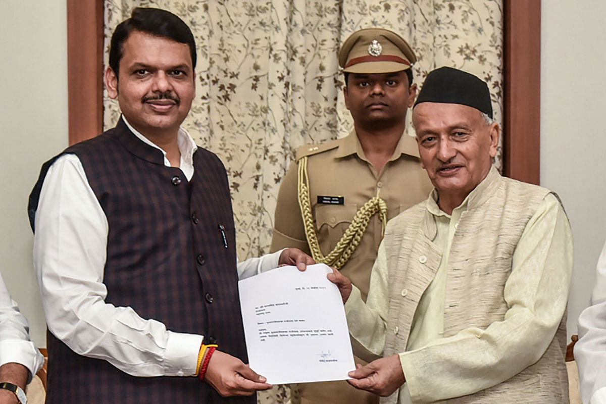 This handout photo released by the Raj Bhavan - Governor`s Residence of Mumbai on 26 November 2019 shows Bharatiya Janata Party (BJP) leader and chief minister of the western Indian state of Maharashtra Devendra Fadnavis (L) tendering his resignation to Maharashtra Governor Bhagat Singh Koshyari (R) in Mumbai. Photo: AFP