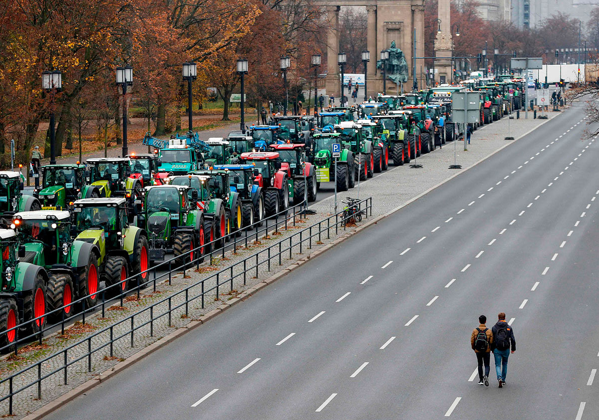 Overall view shows hundreds of farmers lining up with their tractors along `Strasse des 17. Juni` Avenue towards Brandenburg Gate (background) during a protest on 26 November 2019 in Berlin against the German government`s agricultural policy including plans to phase out glyphosate pesticides and to implement more animal protection. Photo: AFP