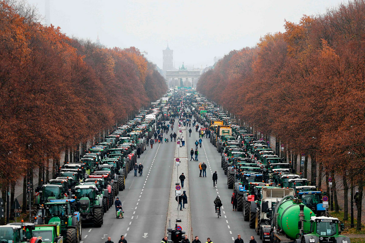 Overall view shows hundreds of farmers lining up with their tractors along `Strasse des 17. Juni` Avenue towards Brandenburg Gate (background) during a protest on 26 November 2019 in Berlin against the German government`s agricultural policy including plans to phase out glyphosate pesticides and to implement more animal protection. Photo: AFP