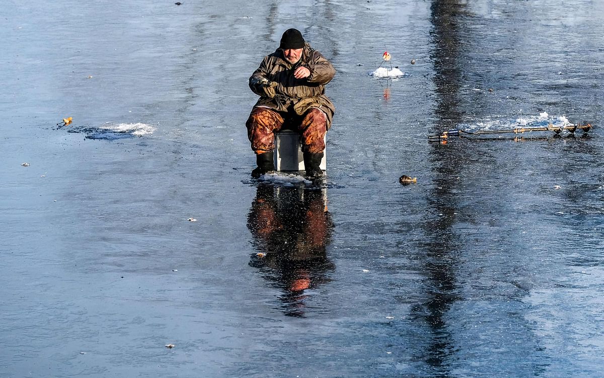 A man fishes on the ice of a frozen pond in a park in the town of Chekhov some 75 km outside Moscow on 25 November 2019. Photo: AFP