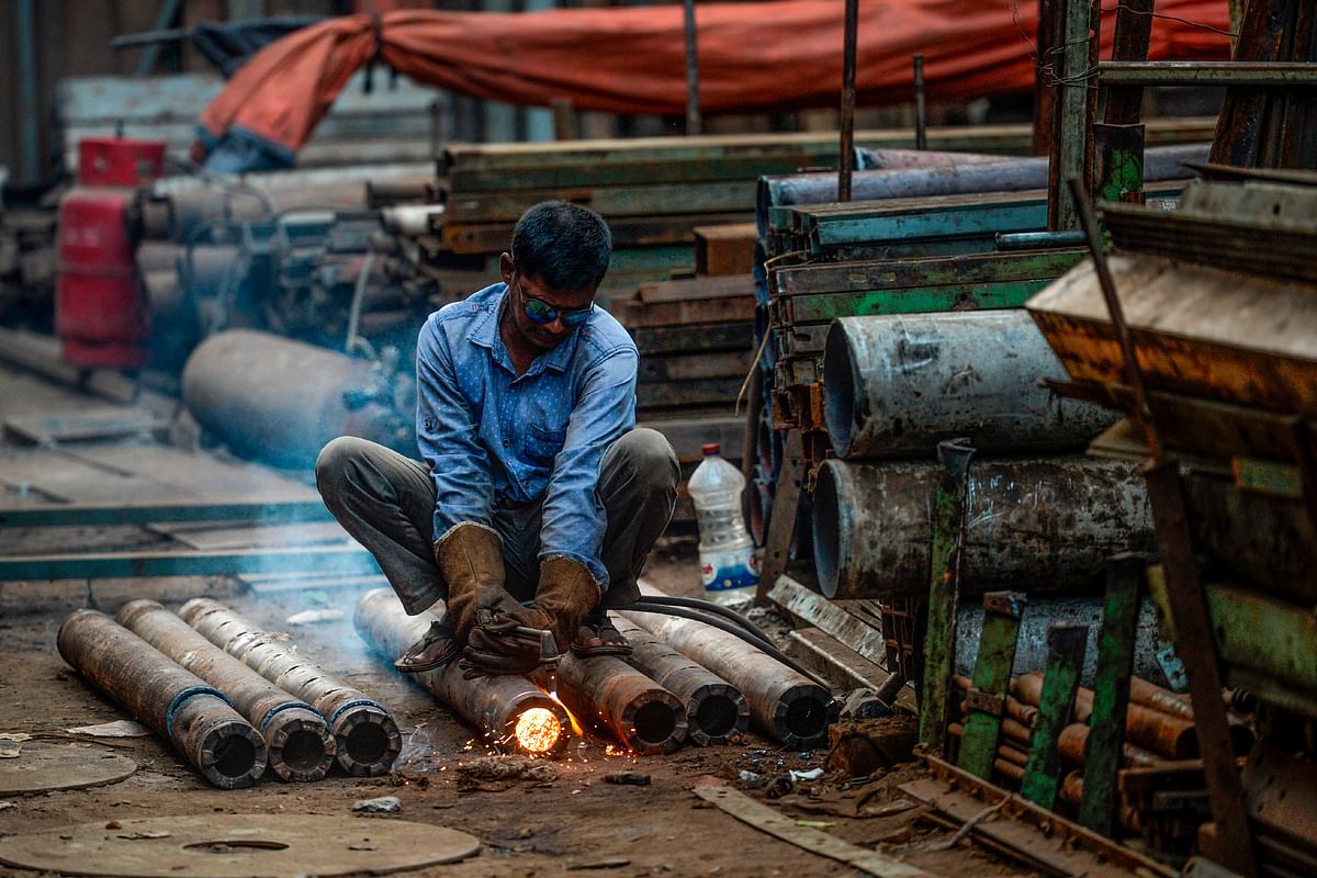 A labourer cuts a steel pipe at a workshop in Dhaka on 25 November 2019. Photo: AFP