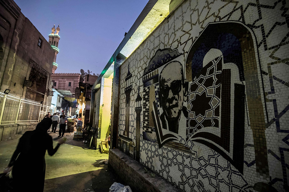 A mural depicting Egyptian novelist and nobel prize winner Naguib Mahfouz is pictured behind the al-Azhar mosque in downtown Cairo on 26 November 2019. The legacy of Islamic Cairo`s most famous son Naguib Mahfouz lives on in its winding lanes 21 years after he became the only Arab to win the Nobel Literature Prize. Photo: AFP