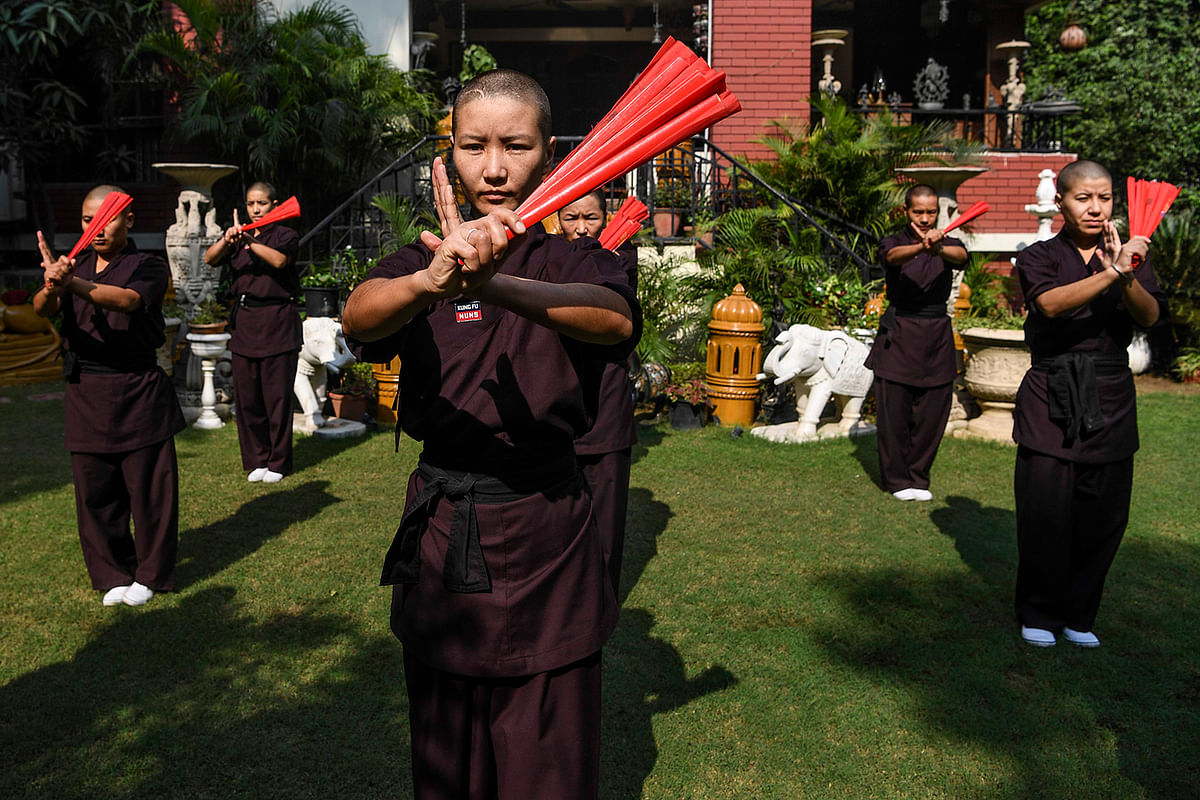 Members of the Kung Fu Nuns group demonstrate their skills in New Delhi. They train with swords and machetes after their prayers and morning chants. Photo: AFP