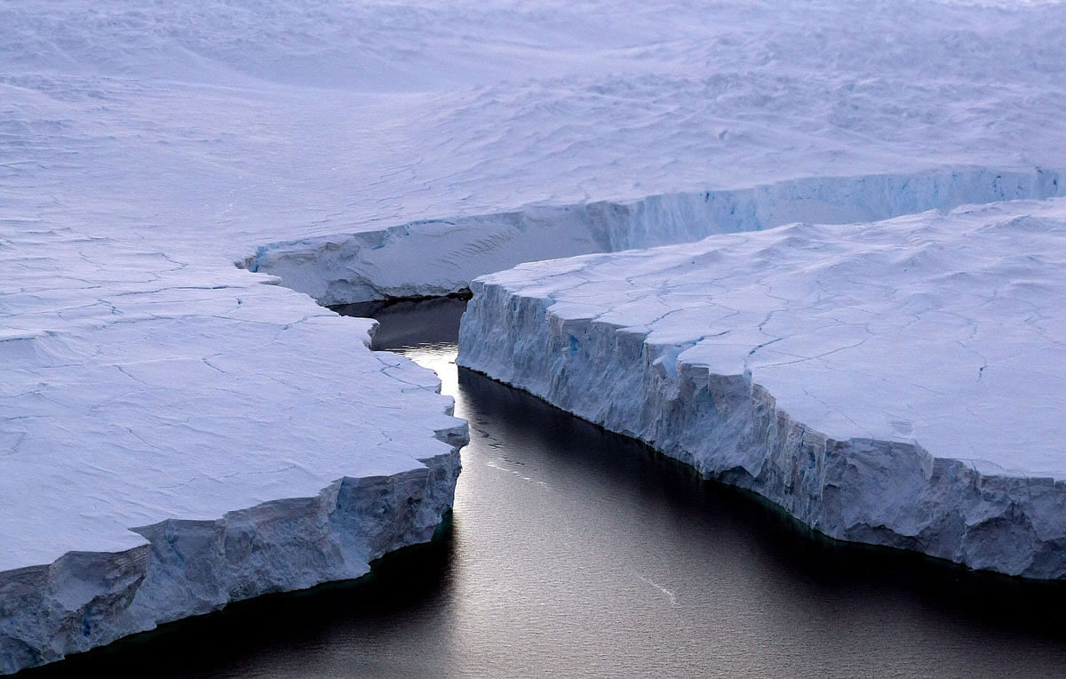 In this file photo taken on 11 January 2008, an enormous iceberg (R) breaks off the Knox Coast in the Australian Antarctic Territory. The world must slash its emissions of planet-warming greenhouse gases by 7.6 per cent every year to 2030 or miss the chance to avert devastating climate change, the United Nations said on 26 November 2019. Photo: AFP