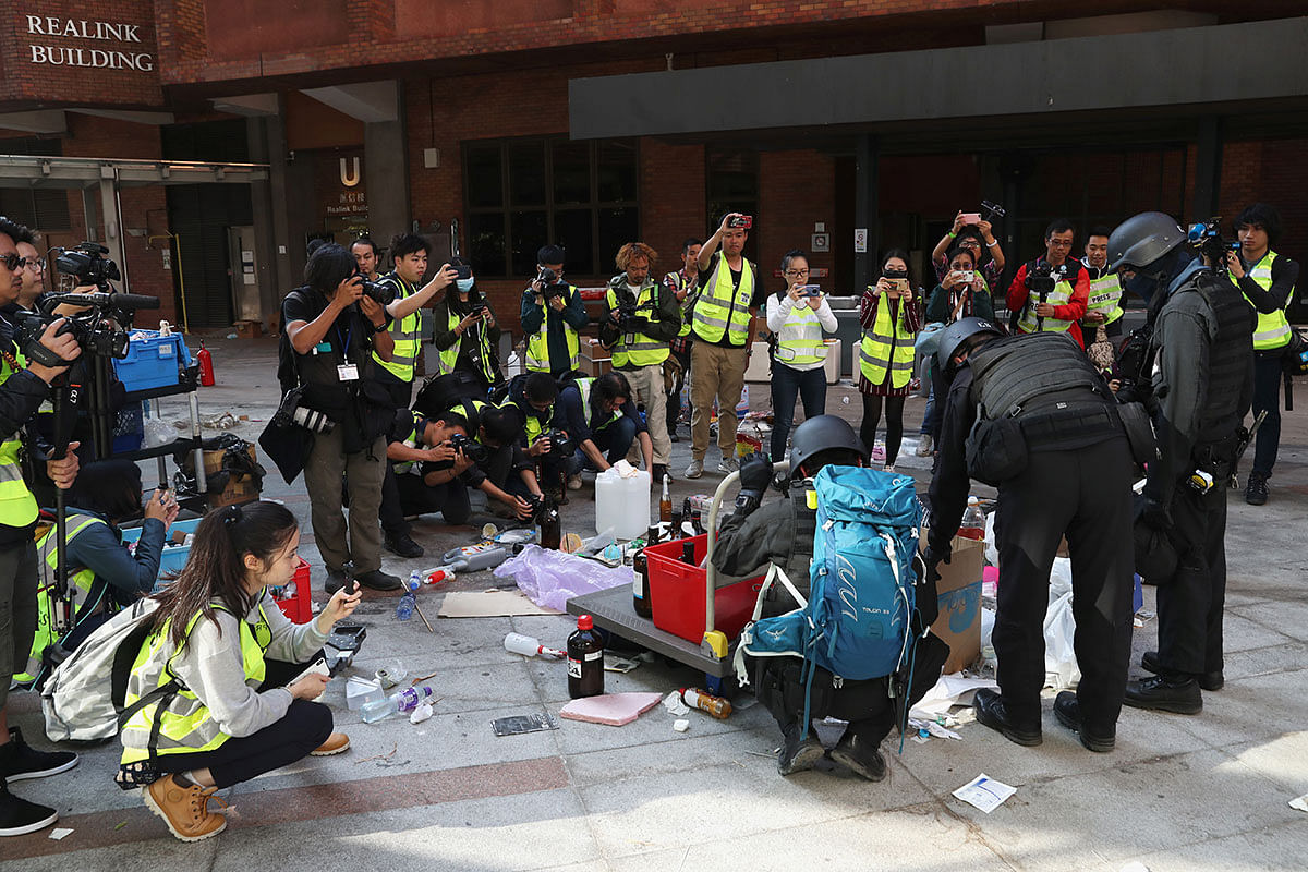 Members of a safety team established by police and local authorities assess and clear unsafe items, next to the media, at the Hong Kong Polytechnic University (PolyU) in Hong Kong, China, on 28 November 2019. Photo: Reuters