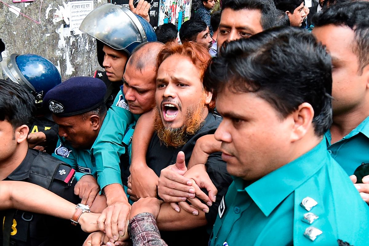 Police escort an Islamist extremist (C) to a prison van after his trial for allegedly plotting the Holey Artisan Bakery cafe attack, at a court in Dhaka on 27 November 2019. Photo: AFP