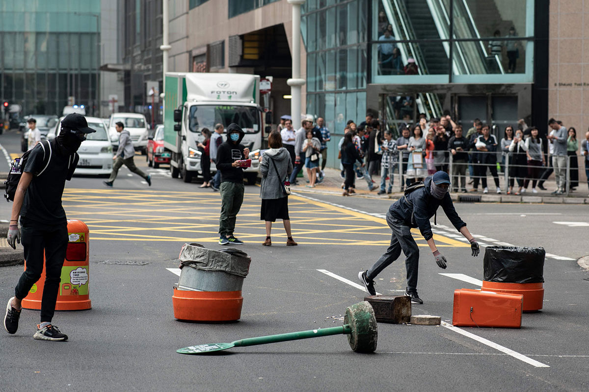 Pro-democracy protesters set up a barricade in the street as people gather in support of the pro-democracy movement during a lunch break rally in the Kowloon Bay area in Hong Kong on 26 November 2019. Photo: AFP