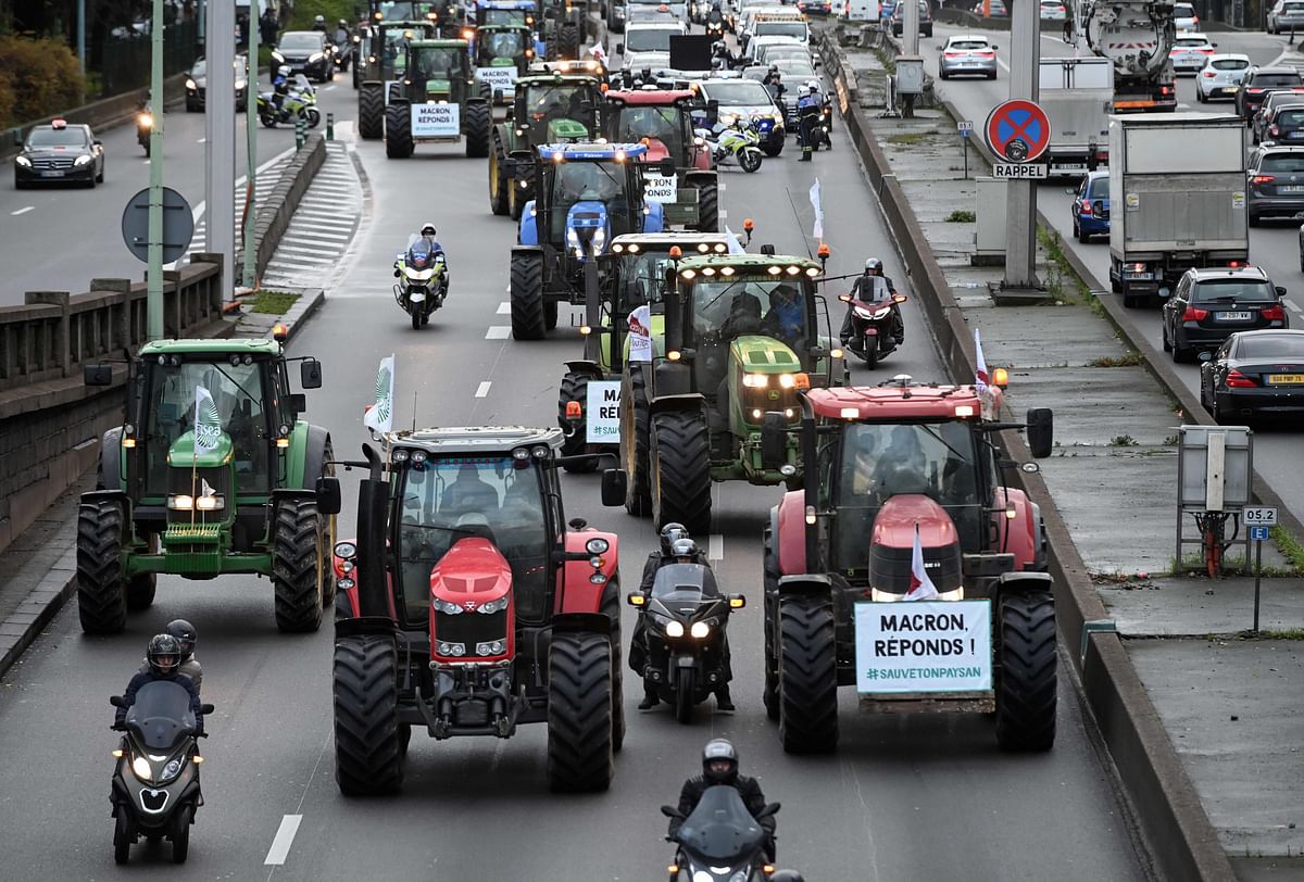 French farmers drive their tractor on the Parisian ring road with a placard (R) reading `Macron, answer !` to protest against government policies, in Paris, on 27 November 2019. Photo: AFP