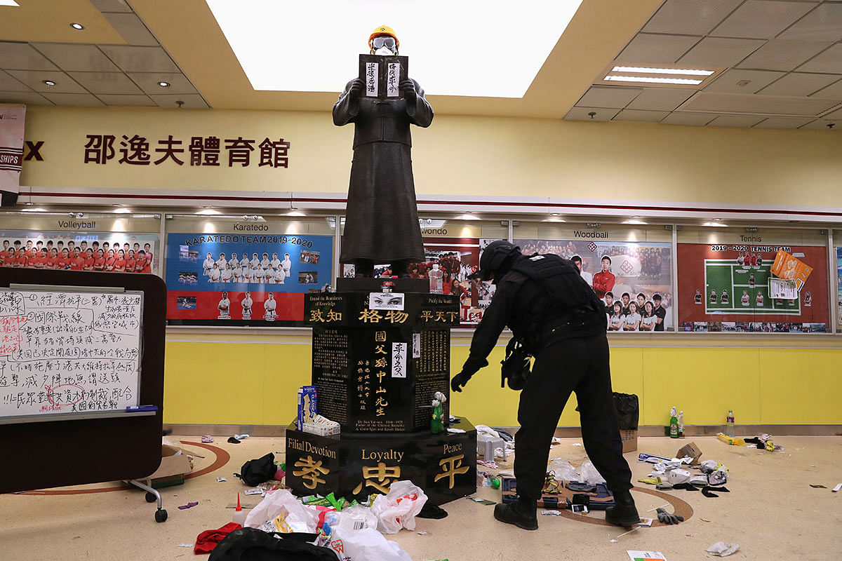 Member of a safety team established by police and local authorities inspects around a statue of Dr Sun Yat-sen, as they assess and clear unsafe items at the Hong Kong Polytechnic University (PolyU) in Hong Kong, China on 28 November 2019. Photo: Reuters