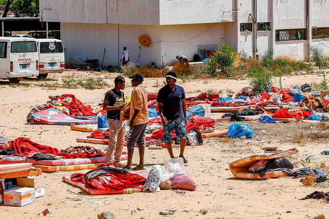 A representational image. Migrants stand and walk outside at a detention centre used by the Libyan Government of National Accord (GNA) in the capital Tripoli`s southern suburb of Tajoura on 3 July 2019, following an air strike on a nearby building that left dozens killed the previous night. Photo: AFP