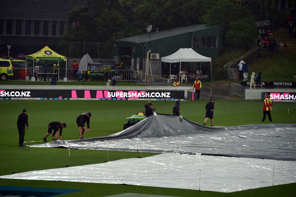 Ground staff cover the pitch as the game is abandoned due to a storm during the first day of the second cricket Test between England and New Zealand at Seddon Park in Hamilton, on 29 November 2019. Photo: AFP