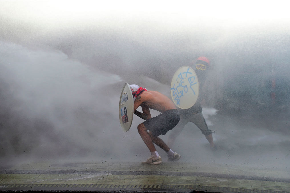 Demonstrators confront a riot police water cannon during a protest against the government in Santiago on 28 November 2019. Furious Chileans have since October 18 been protesting social and economic inequality, and against an entrenched political elite that comes from a small number of the wealthiest families in the country, among other issues. Photo: AFP