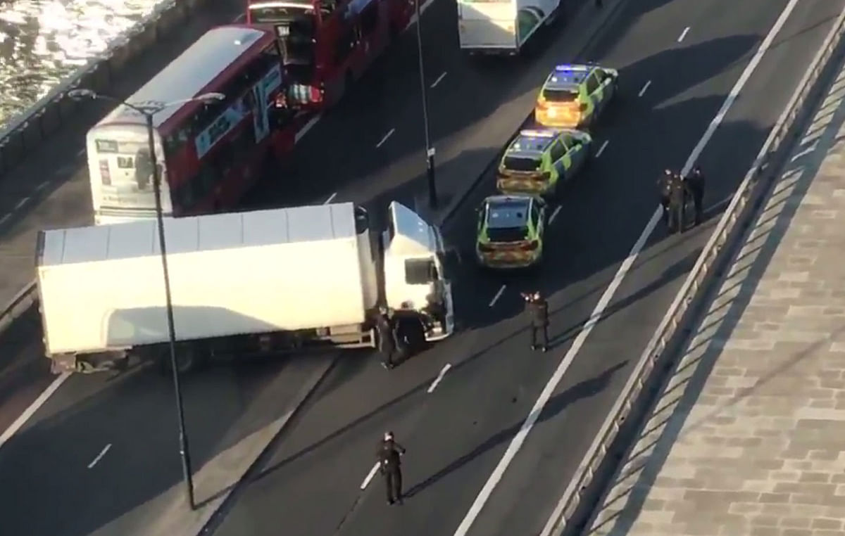 A handout grab taken from a video shows armed police surrounding a white van jackknifed across London Bridge in central London on 29 November, 2019. Photo: AFP