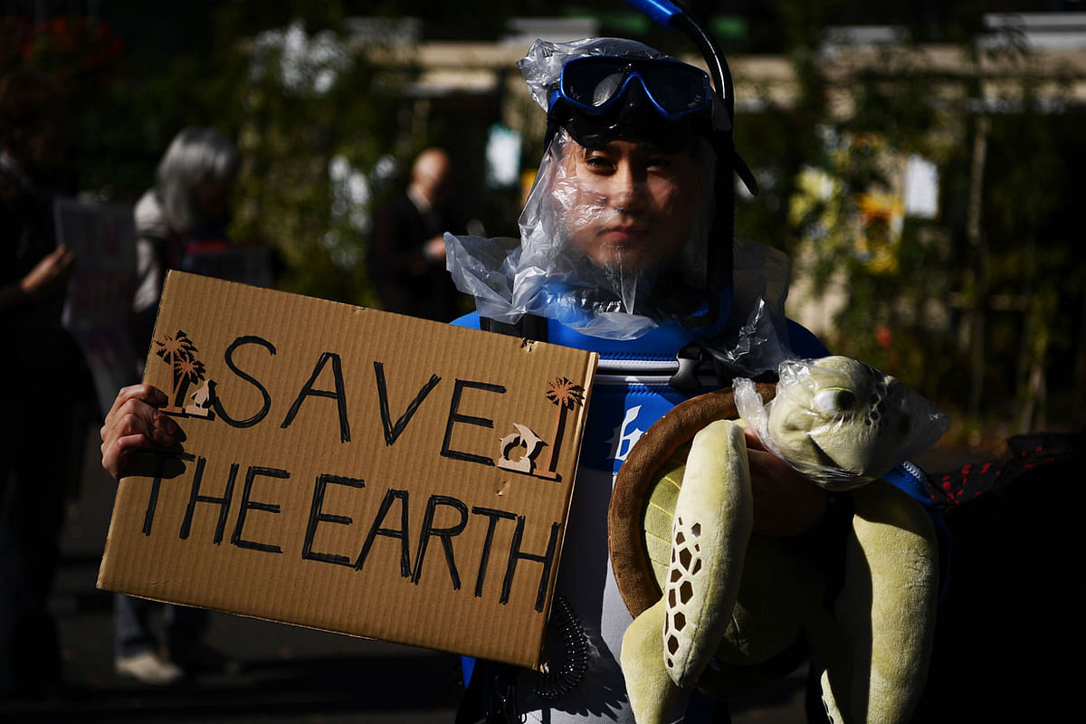 A participants holds up a placard to call for action on climate change during a march in Tokyo on November 29, 2019. Millions of people took to the streets last month in nearly every major global city for a series of `climate strikes`, with the latest demonstrations coming as 200 nations prepare to gather in Madrid in early December for a 12-day UN climate conference. Photo: AFP