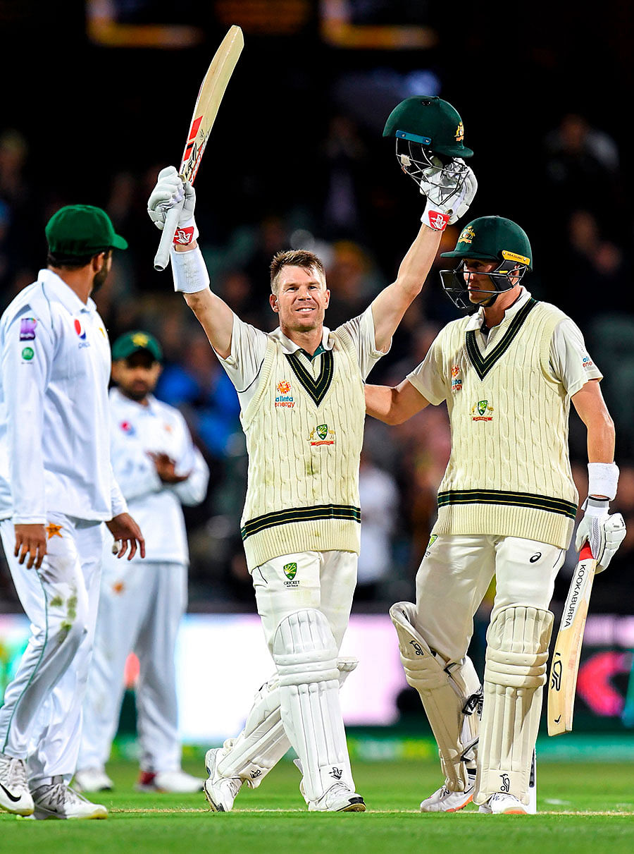 Australian batsman David Warner (C) celebrates scoring his century against Pakistan on the first day of the second cricket Test match in Adelaide on 29 November, 2019. Photo: AFP.