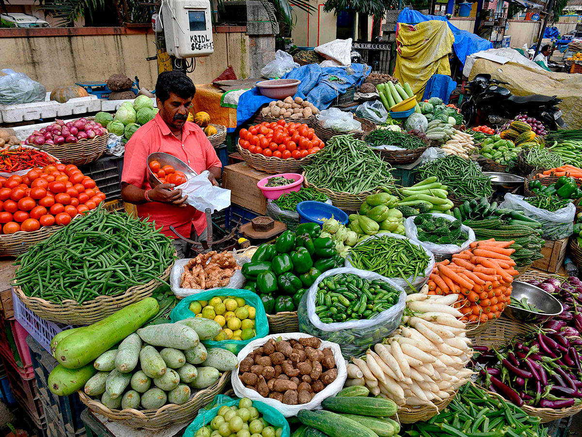 A vendor sells vegetables at the Jayanagar vegetable market in Bangalore on 29 November 2019. Photo: AFP