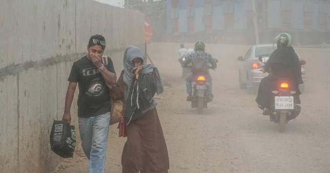 People trying hard to avoid inhaling dust directly while walking at Postogola Bridge in Dhaka. The capital has long been grappling with air pollution. UNB File Photo