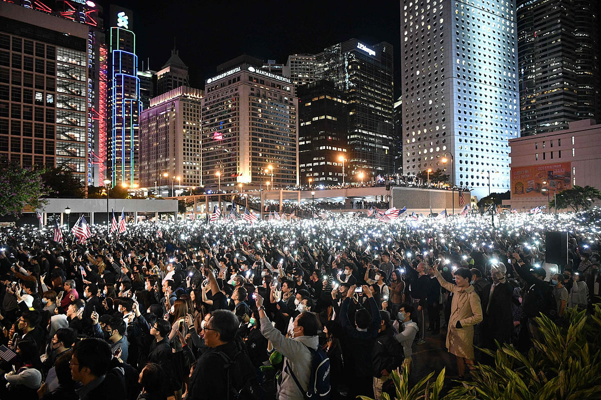 People hold up lights from their mobile phones as they take part in a gathering of thanks at Edinburgh Place in Hong Kong`s Central district on 28 November 2019, after US president Donald Trump signed legislation requiring an annual review of freedoms in Hong Kong. Photo: AFP