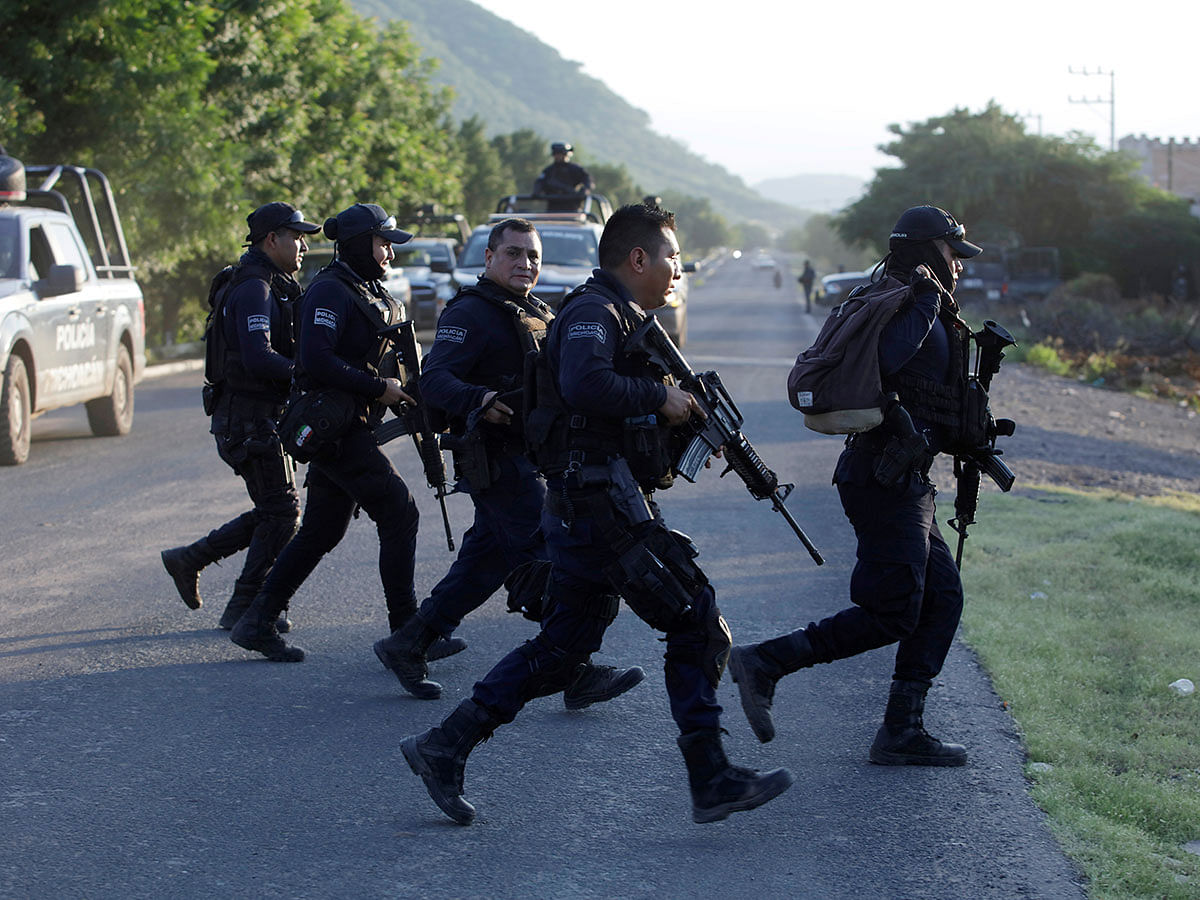 Police officers patrol at a road after fellow police officers were killed during an ambush by suspected cartel hitmen in El Aguaje, in Michoacan state, Mexico on 14 October. Photo: Reuters