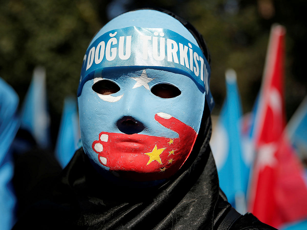 An ethnic Uighur demonstrator wears a mask as she attends a protest against China in front of the Chinese Consulate in Istanbul, Turkey on 1 October. Photo: Reuters