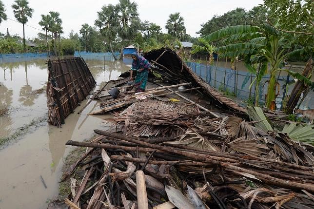 A woman gathers her belongings from a house after cyclone Bulbul hit the area in Koyra, some 100 km from Khulna on 10 November, 2019. Photo: AFP