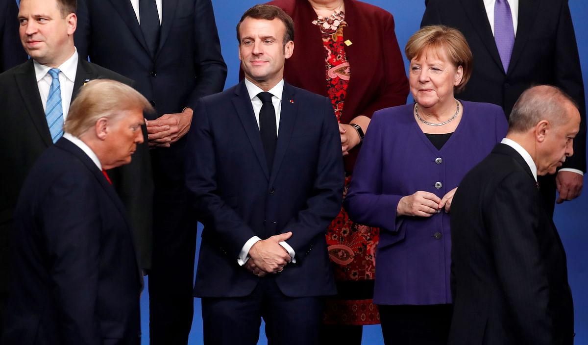 France`s president Emmanuel Macron (2nd L) and Germany`s chancellor Angela Merkel (R) look at US president Donald Trump (front L) and Turkey`s president Recep Tayyip Erdogan (front R) walking past them during a family photo as part of the NATO summit at the Grove hotel in Watford, northeast of London on 4 December. Photo: AFP