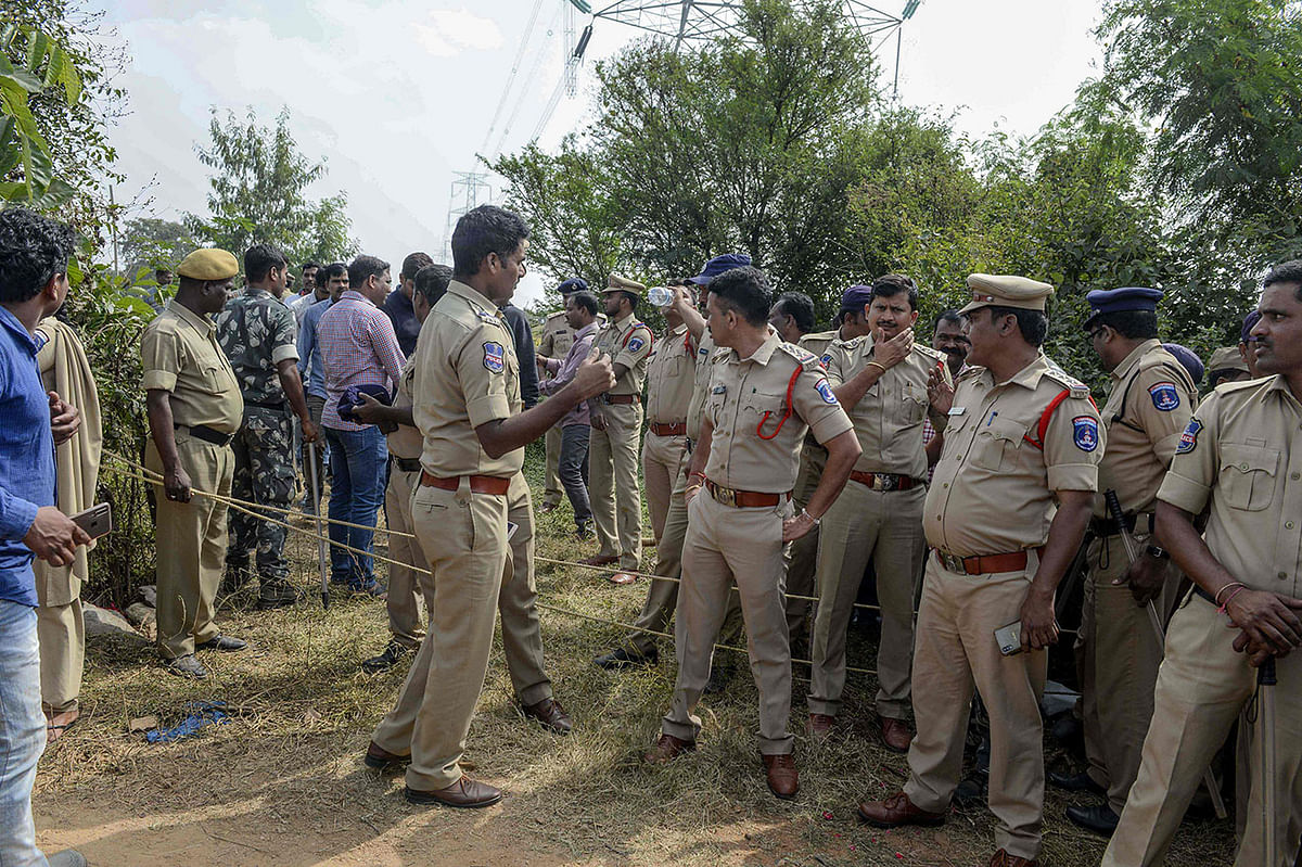 Police personnel stand near the site where they shot dead four detained gang-rape and murder suspects in Shadnagar on 6 December 6, 2019. Photo: AFP