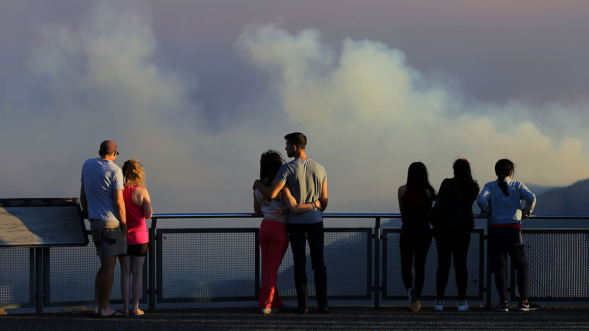 People watch as smoke from the Green Wattle Creek fire is seen from Echo Point lookout in Katoomba, as bushfires continue to blaze in New South Wales, Australia, on 6 December 2019. Photo: Reuters