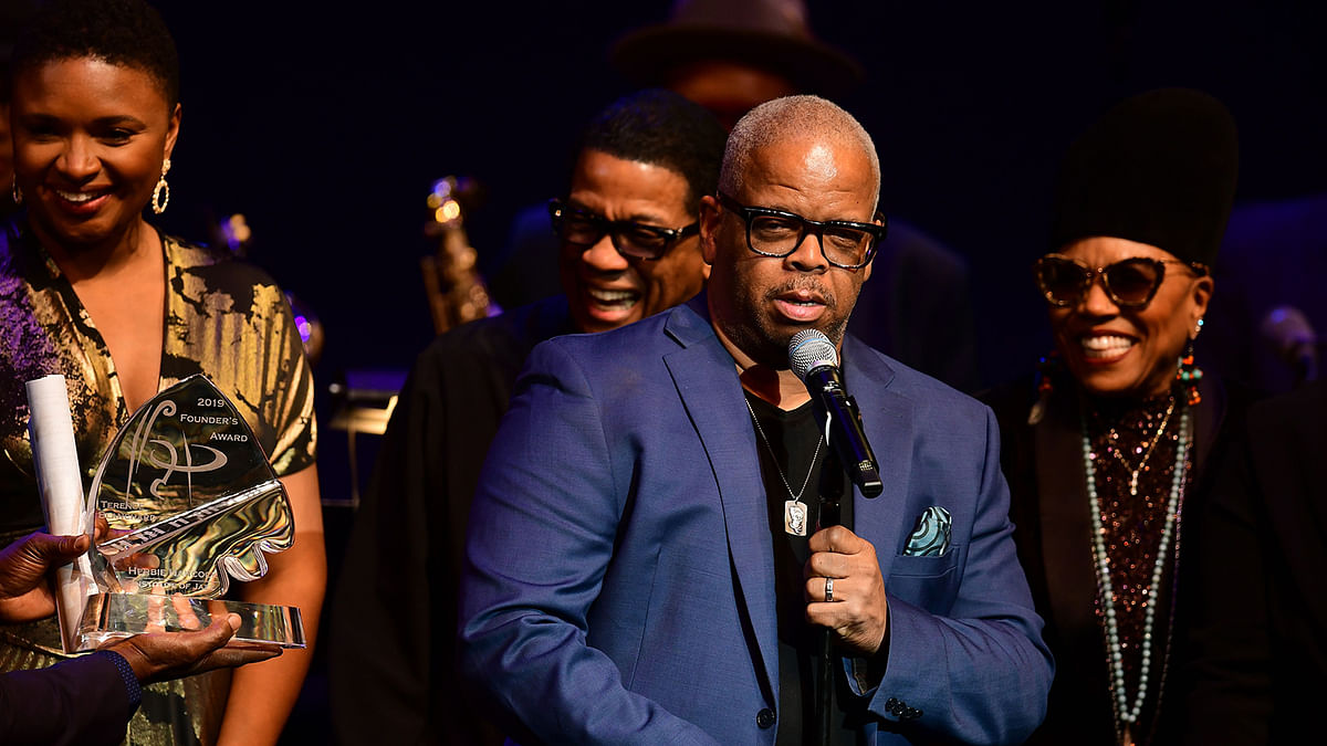 Renown trumpetist and composer Terence Blanchard (C) addresses the audience after receiving the Herbie Hancock Institute of Jazz 2019 Founder`s Award from pianist and keyboardist Herbie Hancock (C-L) at the Kennedy Center in Washington, DC, on 3 December 2019 as vocalists Lizz Wright and Dee Dee Bridgewater (L) stand by. Photo: AFP