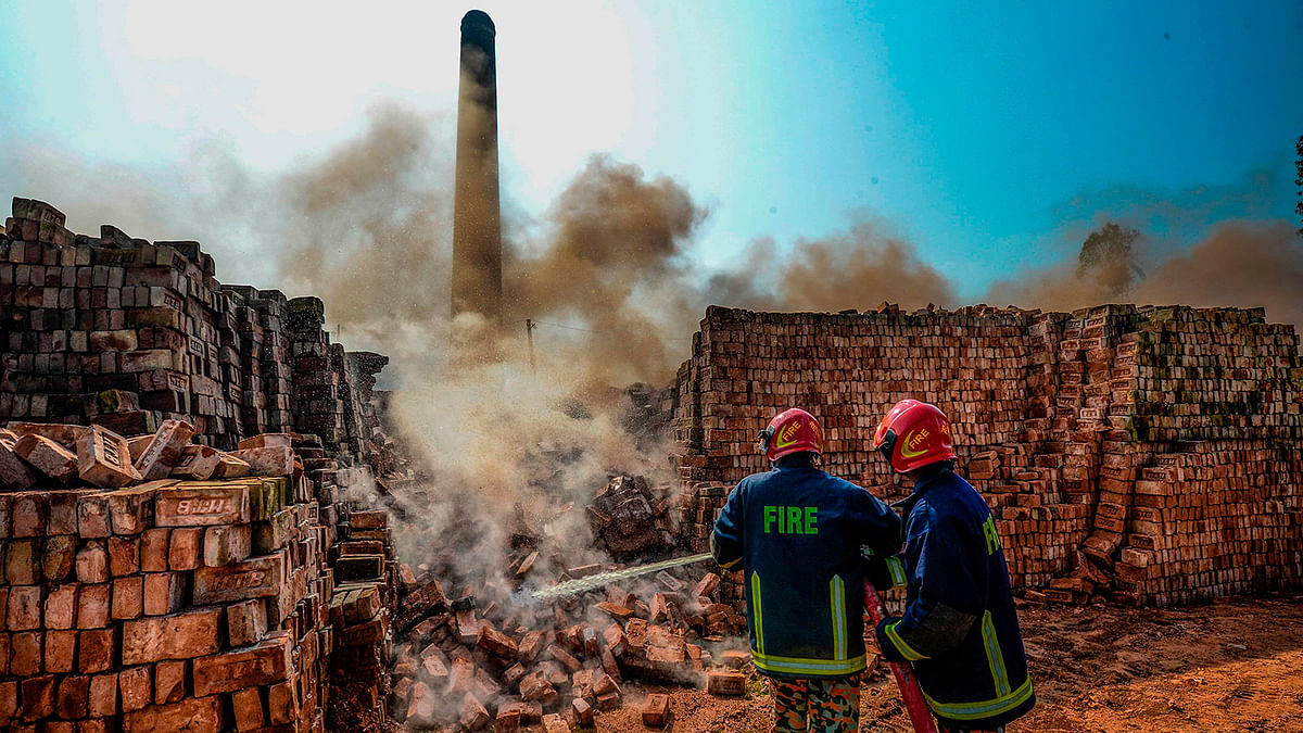 Firefighters extinguish the smoking bricks of an illegal brick factory being demolished following the decision of authorities from the environment department of the environment, forest and climate change ministry on the outskirts of Dhaka on 4 December 2019. Photo: AFP