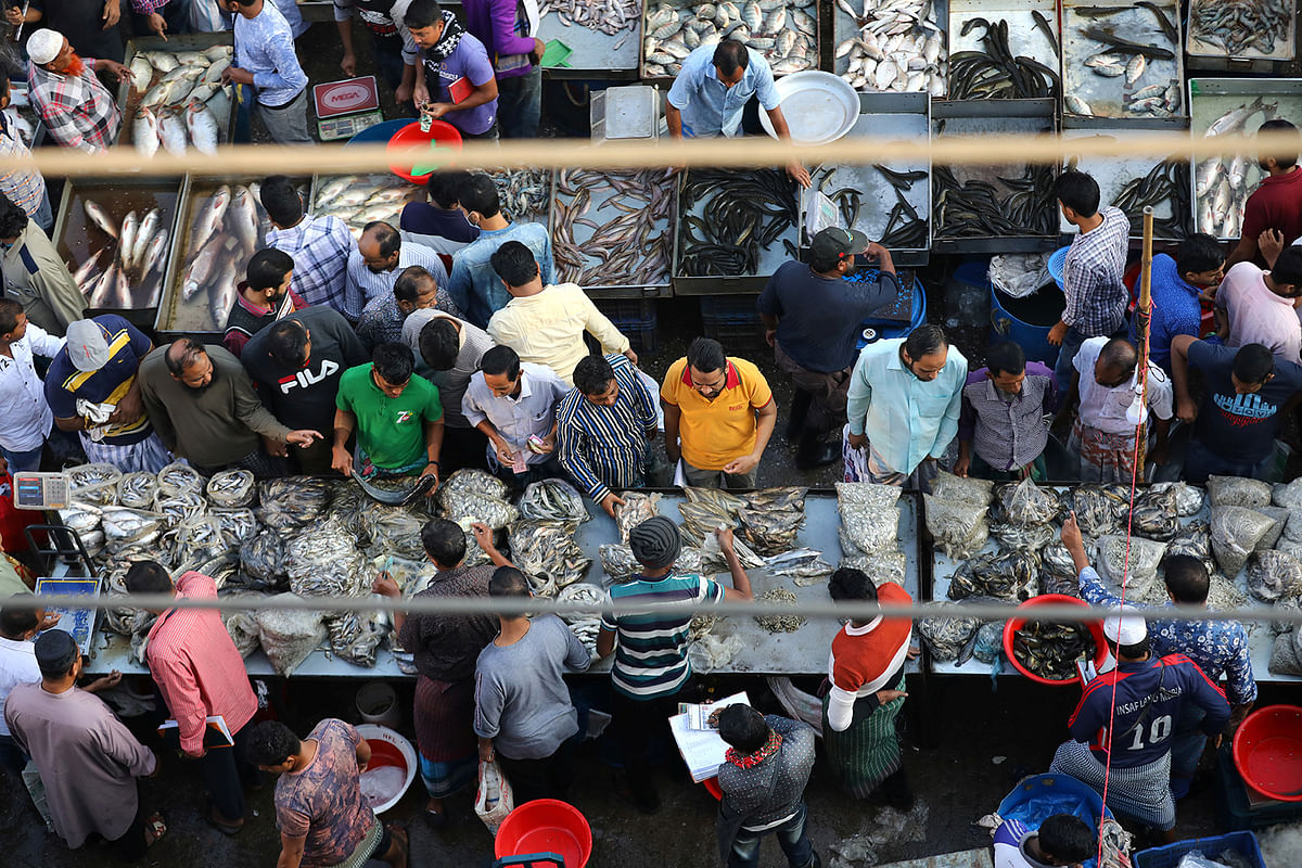 People gather at a wholesale fish market in Dhaka, Bangladesh, 6 December 2019. Photo: Reuters