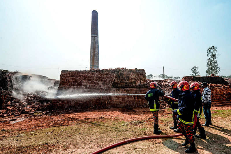 In this photographs taken on 4 December 2019, firefighters spray water over a brick kiln as local authorities prepare to demolish illegal brick kiln on the outskirts of Dhaka. Photo: AFP