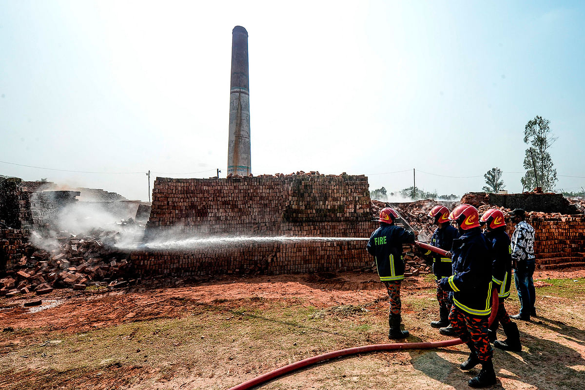 In this photographs taken on 4 December 2019, firefighters spray water over a brick kiln as local authorities prepare to demolish illegal brick kiln on the outskirts of Dhaka. Photo: AFP