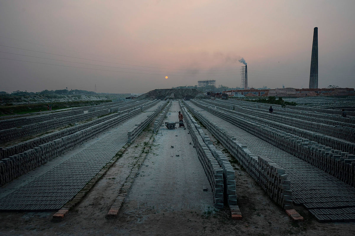 In this photograph taken on 22 November 2019, labourers work in a brick kiln on the outskirts of Dhaka. Excavators flanked by Bangladesh riot police are at work demolishing illegal soot-belching brick kilns around the smog-choked capital Dhaka, forcing migrant labourers out of work and back to their villages. Photo: AFP