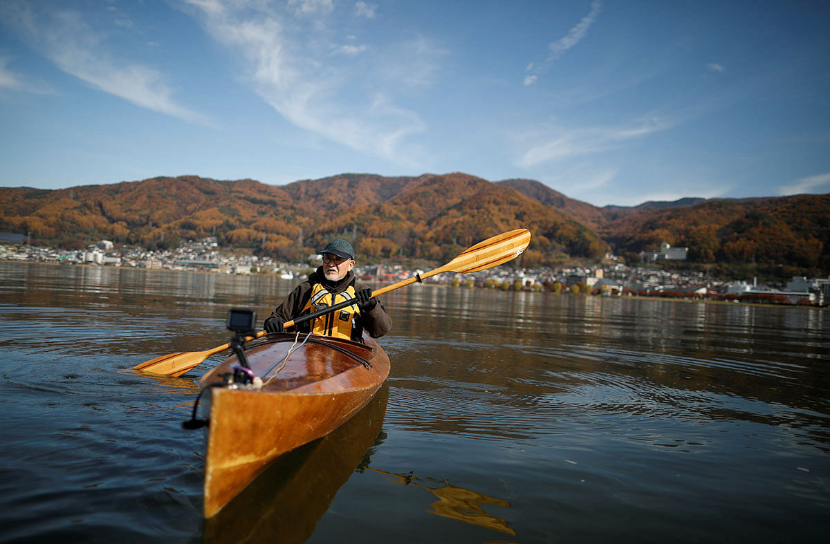 Atsushi Momose starts most mornings paddling his gleaming wooden kayak on the lake, picking up floating debris using long silver tongs. Photo: Reuters