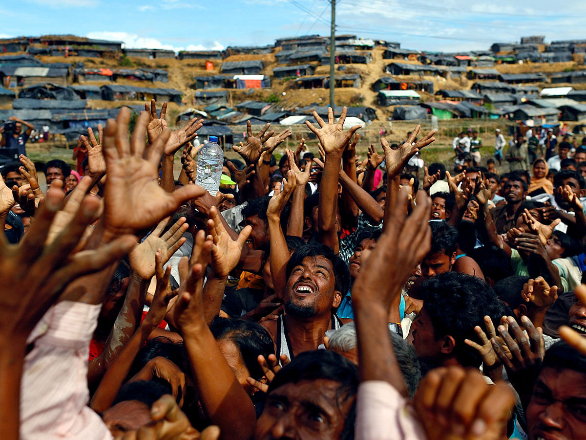 Rohingya refugees stretch their hands to receive aid distributed by local organisations at Balukhali makeshift refugee camp in Cox`s Bazar, Bangladesh, on 14 September 2017. Reuters File Photo