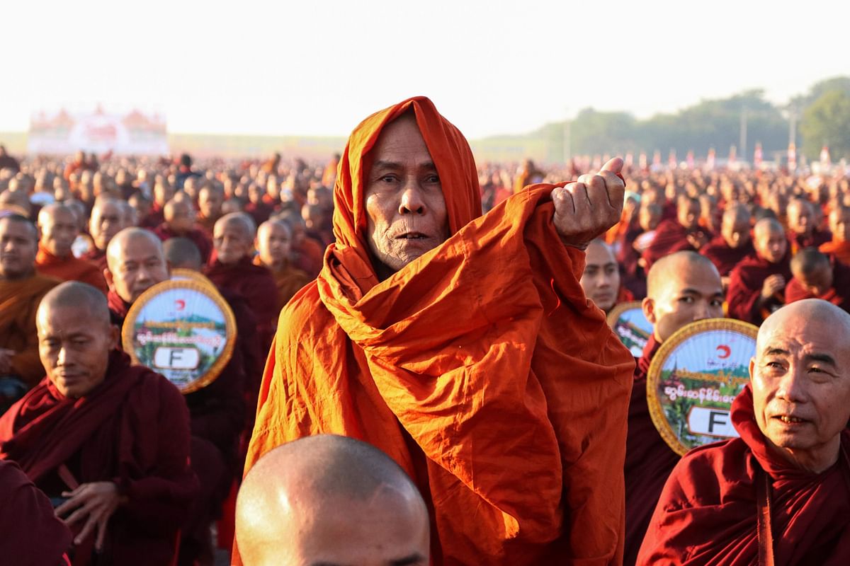 Monks line up for alms during the alms-giving ceremony to 30,000 monks organize by the region government of Mandalay affiliated with Dhammakaya Foundation at Chanmyathazi Airport in Mandalay on 8 December. Photo: AFP