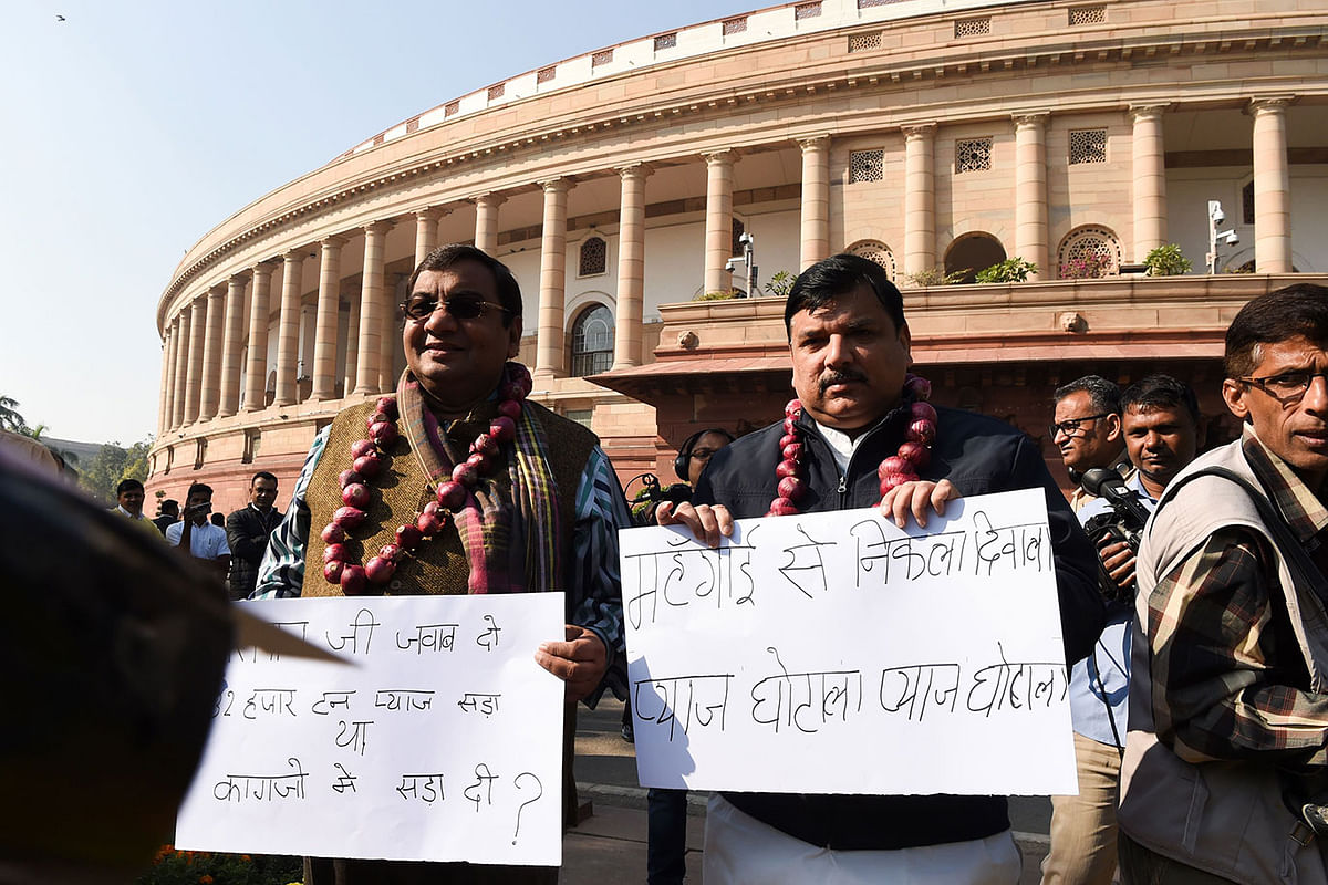 Aam Aadmi Party (AAP) parliament members Sanjay Singh (R) and Shushil Gupta (L) wearing garlands made out of onions display placards to protest against onion price hike at the Parliament House in New Delhi on 3 December 2019. Photo: AFP