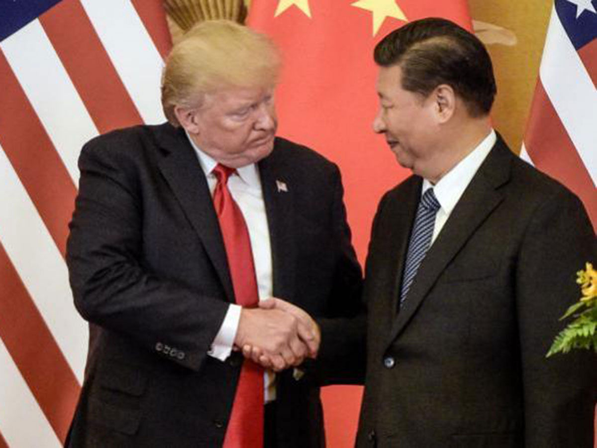 In this file photo taken on 9 November 2017, US president Donald Trump (L) shakes hand with China`s Xi Jinping in Beijing. Photo: AFP
