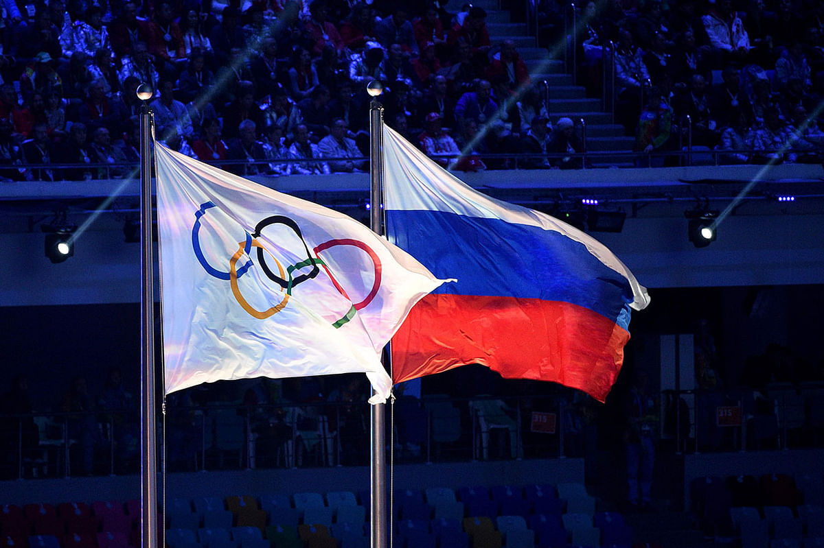 The Olympic flag and the Russian flag flying during the Closing Ceremony of the Sochi Winter Olympics at the Fisht Olympic Stadium in Sochi.