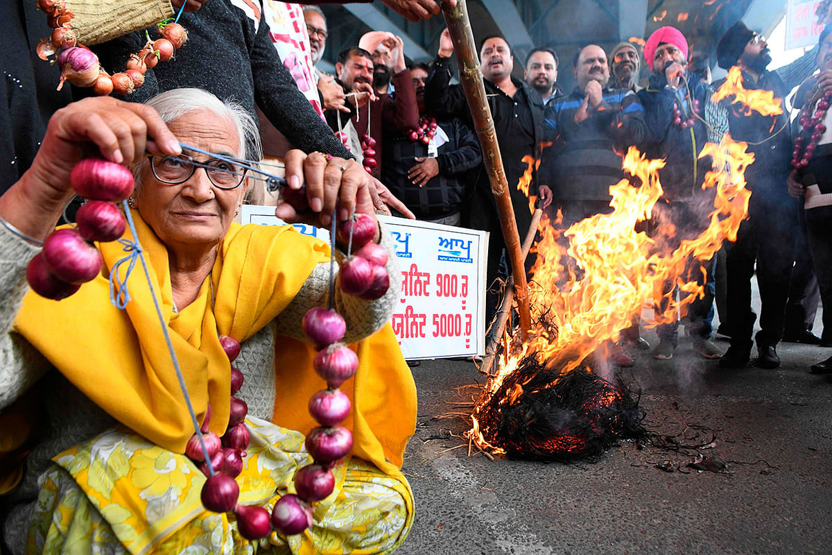 Aam Aadmi Party workers hold garland of onions as they burn an effigy representing inflation during a protest against the spiralling prices of onions in the country and they also protest against the hike in electricity tariffs during demonstration, in Amritsar on 9 December 2019. Photo: AFP
