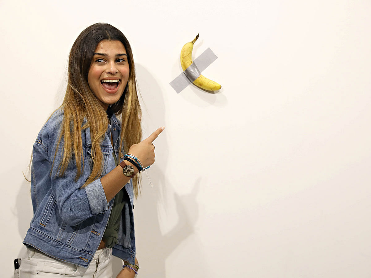 People post in front of Maurizio Cattelan`s `Comedian` presented by Perrotin Gallery and on view at Art Basel Miami 2019 at Miami Beach Convention Center on 6 December 2019 in Miami Beach, Florida. Photo: AFP