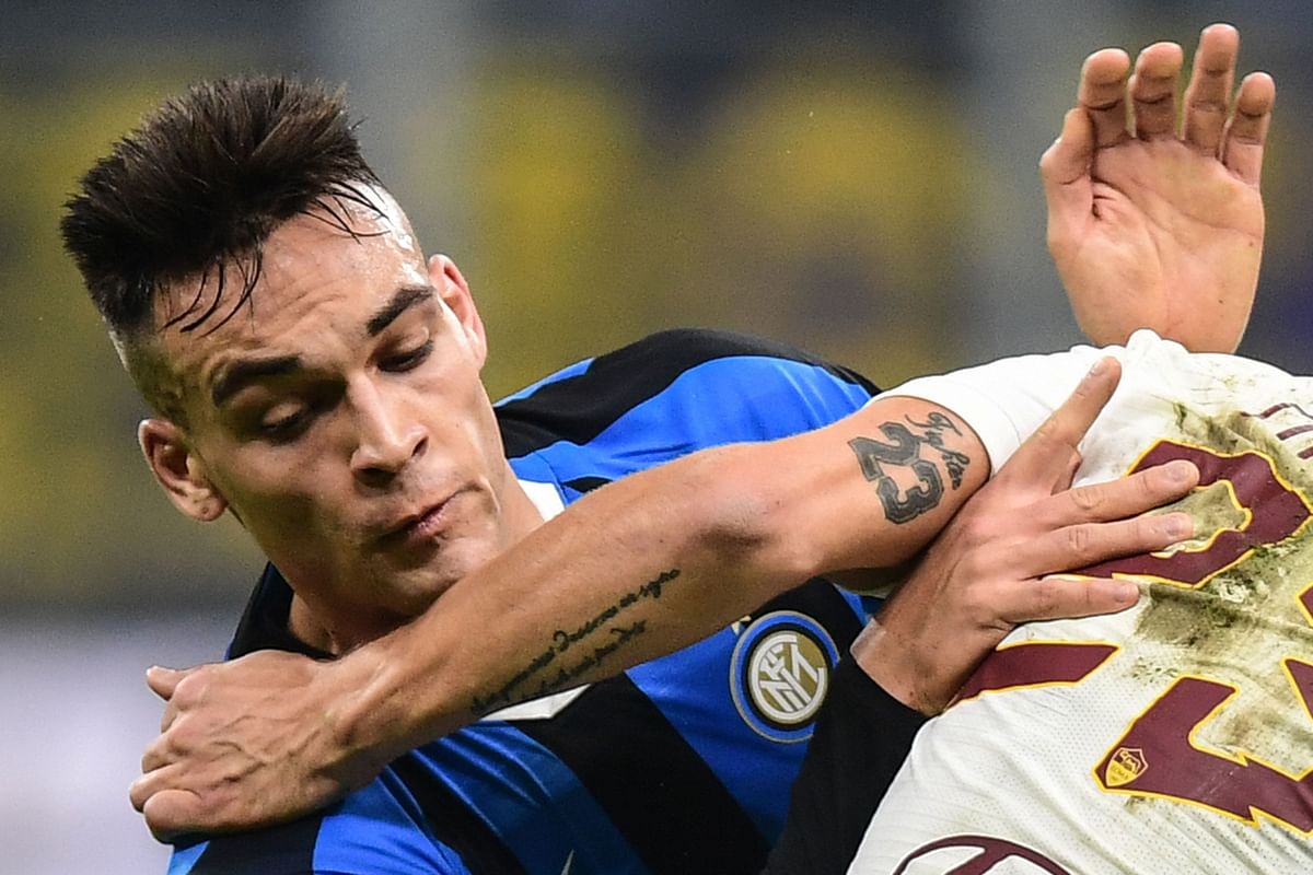 Inter Milan`s Argentinian forward Lautaro Martinez is held off during the Italian Serie A football match Inter Milan vs AS Rome on 6 December 2019 at the San Siro stadium in Milan. Photo: AFP