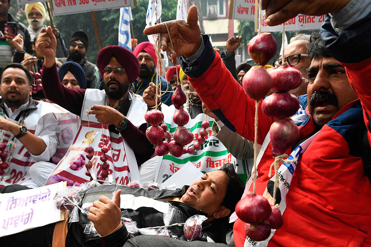 Aam Aadmi Party workers hold garland of onions during a protest against the spiralling prices of onions in the country and the hike in electricity tariffs during a demonstration, in Amritsar on 9 December 2019. Photo: AFP