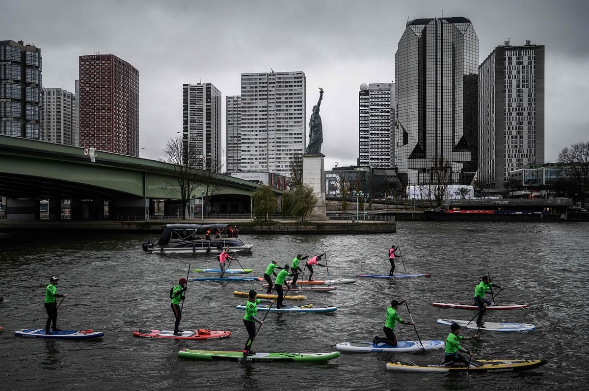 Competitors take part in the Nautic Paddle Race on the Seine river near the Statue of Liberty next to The Grenelle Bridge in Paris on 8 December 2019. Photo: AFP